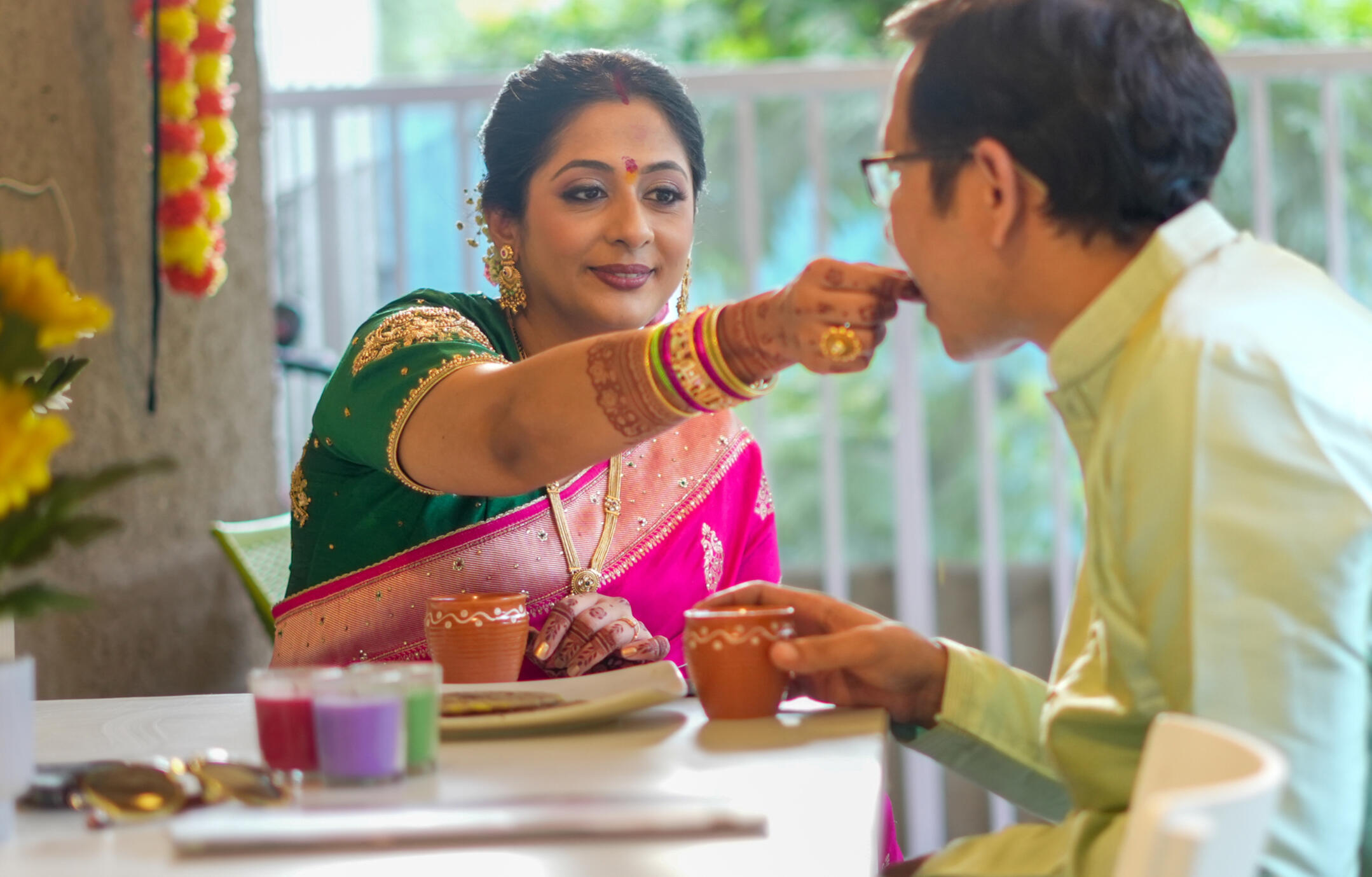 Candid wedding moment of Shweta feeding Sandeep during their traditional wedding celebration while sharing tea together.