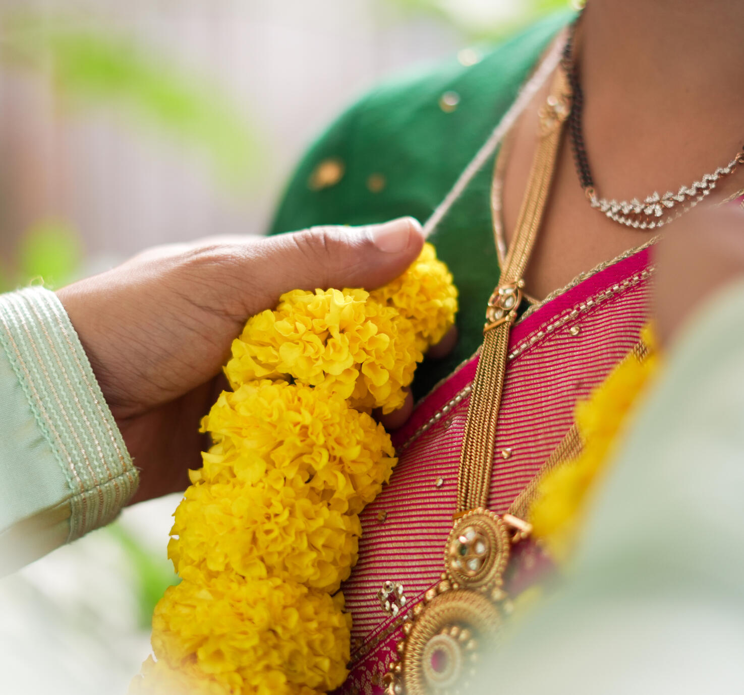 Close-up candid moment of wedding garland rituals between Shweta and Sandeep Rawat during their traditional ceremony.